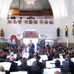 Director musical y músicos interpretando en una iglesia