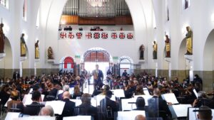 Director musical y músicos interpretando en una iglesia